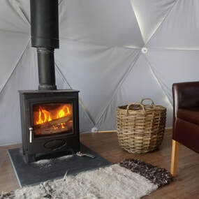 The interior of our luxury Glamping Dome with wood burner